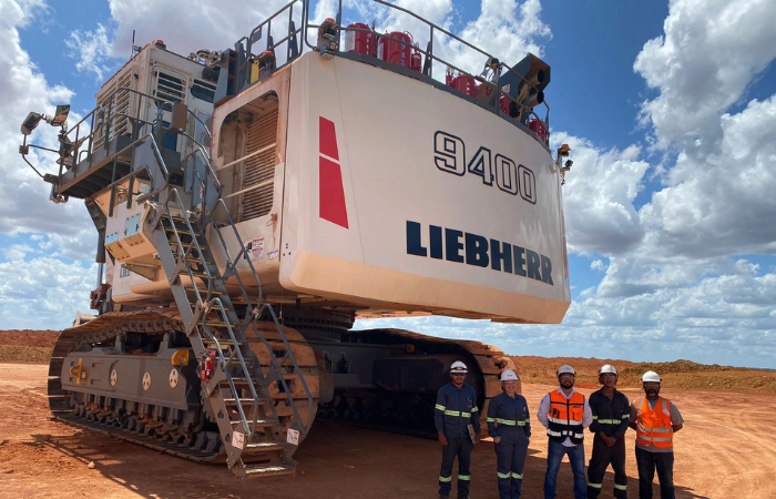 technicians standing beside a Liebherr 9400 with AFEX fire suppression tanks